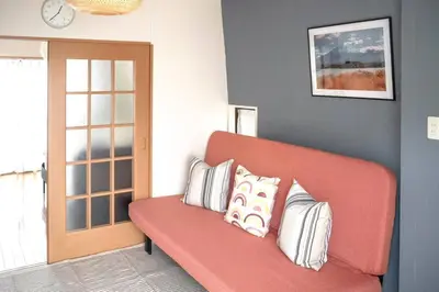 a living room with a red couch with pillows on it at \u65b0\u5bbf\u4e00\u7ad95\u5206\u949f-301-\u9910\u9986\u8d2d\u7269\u8857-\u5b89\u9759\u54c1\u8d28\u516c\u5bd3-\u76f4\u8fbe\u7687\u5c45\u79cb\u53f6\u539f in Tokyo