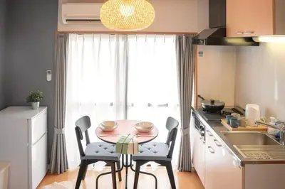 a kitchen with a table and chairs in a kitchen at \u65b0\u5bbf\u4e00\u7ad95\u5206\u949f-301-\u9910\u9986\u8d2d\u7269\u8857-\u5b89\u9759\u54c1\u8d28\u516c\u5bd3-\u76f4\u8fbe\u7687\u5c45\u79cb\u53f6\u539f in Tokyo