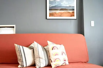 an orange couch with pillows on it with a picture at \u65b0\u5bbf\u4e00\u7ad95\u5206\u949f-301-\u9910\u9986\u8d2d\u7269\u8857-\u5b89\u9759\u54c1\u8d28\u516c\u5bd3-\u76f4\u8fbe\u7687\u5c45\u79cb\u53f6\u539f in Tokyo
