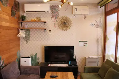 a living room with a couch and a tv at Rakuna Inn \u6cb3 Oshiage in Tokyo
