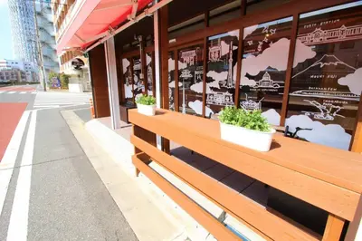 two potted plants on a wooden bench outside a store at Rakuna Inn \u6cb3 Oshiage in Tokyo