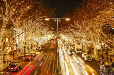 a busy city street with cars and trees decorated with lights at Rakuna Inn \u6cb3 Oshiage in Tokyo