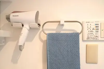 a hair dryer and a towel hanging on a wall at \u65b0\u5bbf\u4e00\u7ad95\u5206\u949f-302-\u9910\u9986\u8d2d\u7269\u8857-\u5b89\u9759\u54c1\u8d28\u516c\u5bd3-\u76f4\u8fbe\u7687\u5c45\u79cb\u53f6\u539f in Tokyo