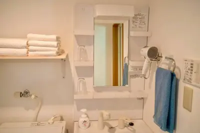 a bathroom with a sink and a mirror and towels at \u65b0\u5bbf\u4e00\u7ad95\u5206\u949f-302-\u9910\u9986\u8d2d\u7269\u8857-\u5b89\u9759\u54c1\u8d28\u516c\u5bd3-\u76f4\u8fbe\u7687\u5c45\u79cb\u53f6\u539f in Tokyo