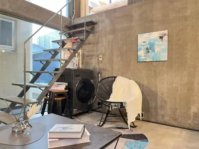 a living room with a spiral staircase and a chair at \u590f\u76ee\u5742\u306e\u9593Room2 in Tokyo