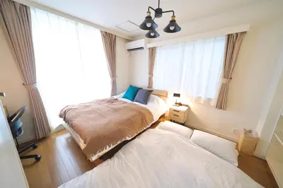 a bedroom with two beds and a window at FINOA Penthouse Suite Ikebukuro Sunshine in Tokyo