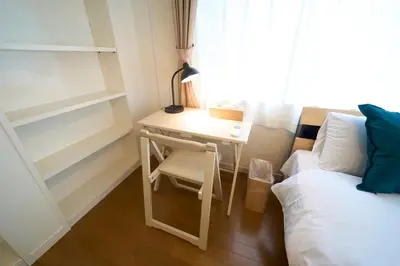 a bedroom with a desk next to a bed and a window at FINOA Penthouse Suite Ikebukuro Sunshine in Tokyo