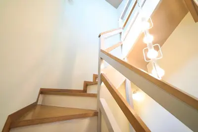 a staircase in a home with wooden stairs and a light fixture at FINOA Penthouse Suite Ikebukuro Sunshine in Tokyo