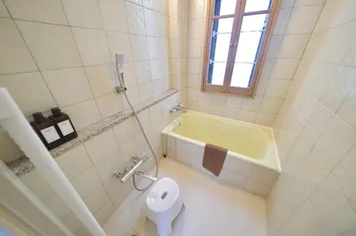a bathroom with a tub and a toilet and a sink at FINOA Penthouse Suite Ikebukuro Sunshine in Tokyo