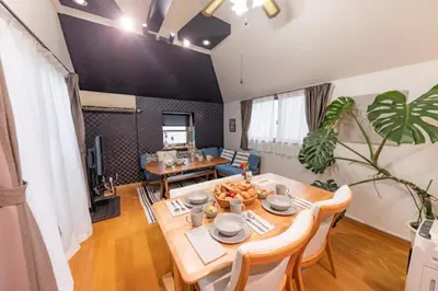 a dining room and living room with a table and chairs at NOT A HOME\u4e80\u6709 \u99c5\u5f92\u6b695\u5206 \u7121\u6599\u99d0\u8eca\u5834 \u30c7\u30a3\u30ba\u30cb\u30fc\u307e\u3067\u8eca22\u5206 \u7fbd\u7530\u7a7a\u884c\u30d0\u30b9\u76f4\u901a 90m2 in Tokyo