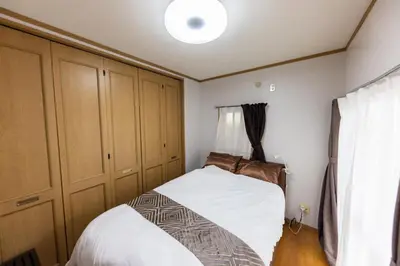 a small bedroom with a bed and a window at NOT A HOME\u4e80\u6709 \u99c5\u5f92\u6b695\u5206 \u7121\u6599\u99d0\u8eca\u5834 \u30c7\u30a3\u30ba\u30cb\u30fc\u307e\u3067\u8eca22\u5206 \u7fbd\u7530\u7a7a\u884c\u30d0\u30b9\u76f4\u901a 90m2 in Tokyo