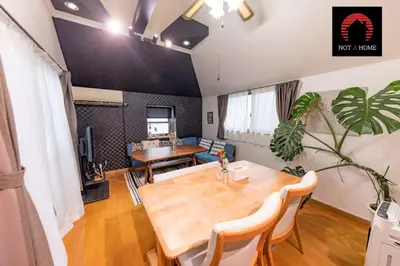 a living room with a table and a couch at NOT A HOME\u4e80\u6709 \u99c5\u5f92\u6b695\u5206 \u7121\u6599\u99d0\u8eca\u5834 \u30c7\u30a3\u30ba\u30cb\u30fc\u307e\u3067\u8eca22\u5206 \u7fbd\u7530\u7a7a\u884c\u30d0\u30b9\u76f4\u901a 90m2 in Tokyo
