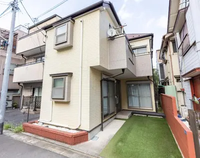 an apartment building with a lawn in front of it at NOT A HOME\u4e80\u6709 \u99c5\u5f92\u6b695\u5206 \u7121\u6599\u99d0\u8eca\u5834 \u30c7\u30a3\u30ba\u30cb\u30fc\u307e\u3067\u8eca22\u5206 \u7fbd\u7530\u7a7a\u884c\u30d0\u30b9\u76f4\u901a 90m2 in Tokyo
