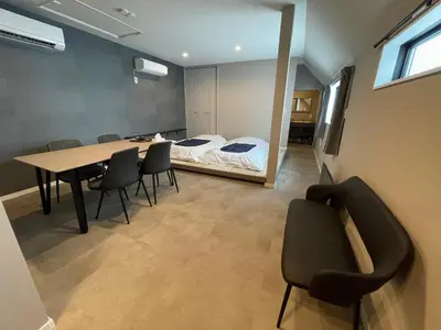 a room with a table and chairs and a bed at COTO Premium Shibuya B in Tokyo