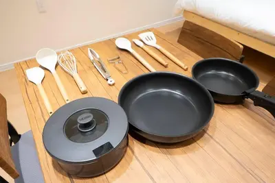 a wooden table with two pans and utensils on it at \u82b1\u5bbf\u6d45\u8349\u4e8c\u756a Hanayado Asakusa2 in Tokyo