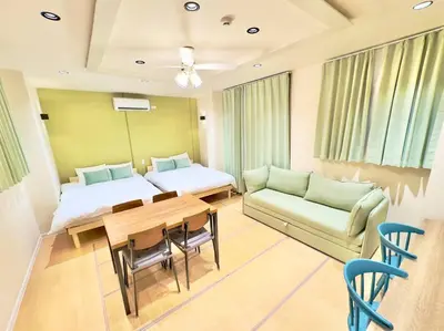 a room with two beds and a table and a couch at \u82b1\u5bbf\u6d45\u8349\u4e8c\u756a Hanayado Asakusa2 in Tokyo