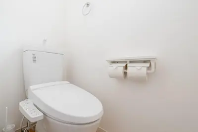a bathroom with a toilet and two rolls of toilet paper at \u5343\u4f4f\u5bff\u753a1f in Tokyo