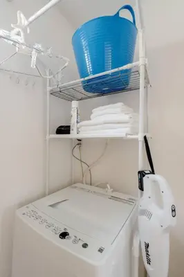 a white washing machine with a blue basket on a shelf at \u5343\u4f4f\u5bff\u753a2f 3f in Tokyo