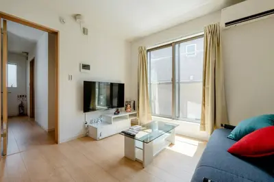 a living room with a blue couch and a tv at \u5343\u4f4f\u5bff\u753a2f 3f in Tokyo