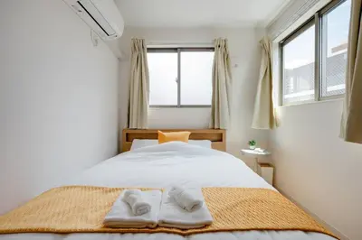 a bedroom with a bed with two towels on it at \u5343\u4f4f\u5bff\u753a2f 3f in Tokyo