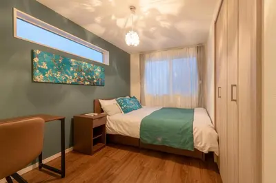 a small bedroom with a bed and a window at \u7d50\u5eb5\u6708\u82b1 in Tokyo