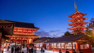 a group of people walking in front of a pagoda at \u516b\u5e836\u4e01\u76ee in Tokyo