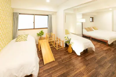 a bedroom with two beds and a table and a chair at HARMONIa\u6771\u4eac\u5800\u5207202 in Tokyo