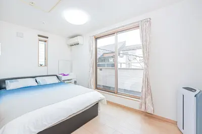 a bedroom with a bed and a large window at Otsuka house with 3BR near the Yamanote line in Tokyo