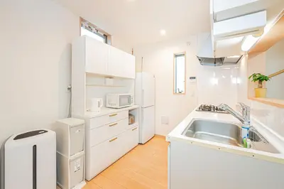 a white kitchen with a sink and a refrigerator at Otsuka house with 3BR near the Yamanote line in Tokyo