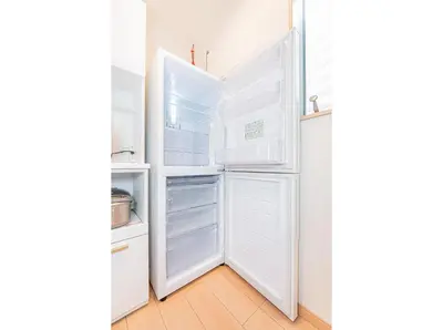 a white refrigerator with its doors open in a kitchen at Otsuka house with 3BR near the Yamanote line in Tokyo