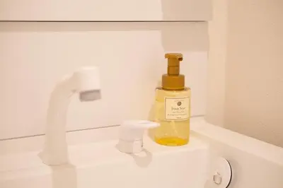 a bottle of soap sitting on top of a sink at Six7 APT\u4e09\u30ce\u8f2a in Tokyo