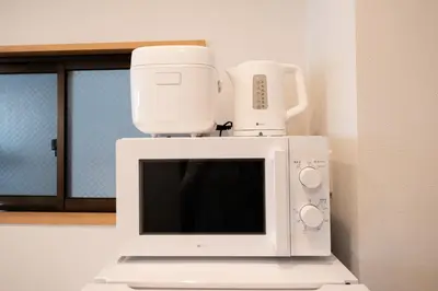 a microwave with a coffee maker on top of it at Six7 APT\u4e09\u30ce\u8f2a in Tokyo