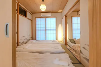 a row of beds in a room with windows at Six7 APT\u4e09\u30ce\u8f2a in Tokyo