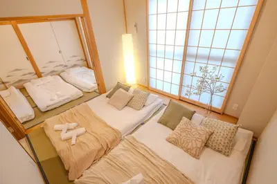a small room with three beds and a window at Six7 APT\u4e09\u30ce\u8f2a in Tokyo