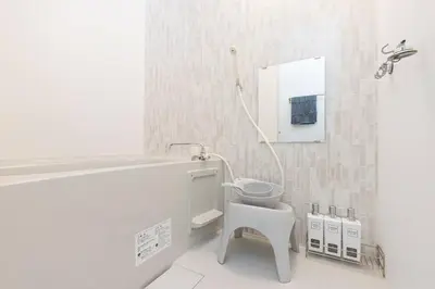 a white bathroom with a toilet and a mirror at Nishisugamo Full Renovated House Next to a Cherry Blossom Park in Tokyo