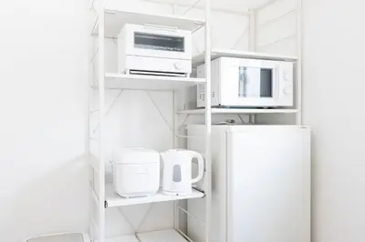 a kitchen with white appliances and a refrigerator at Nishisugamo Full Renovated House Next to a Cherry Blossom Park in Tokyo