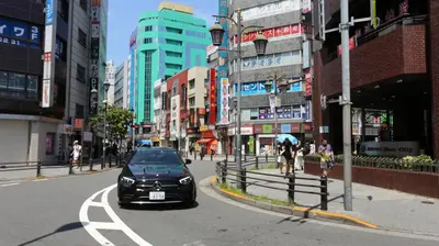 a black car driving down a street in a city at Mizuken Home in Tokyo