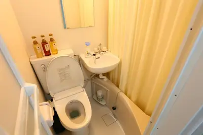 a small bathroom with a toilet and a sink at Mizuken Home in Tokyo