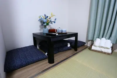 a small black table with a vase of flowers on it at Mizuken Home in Tokyo