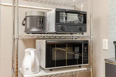 three microwaves on a shelf in a kitchen at \u7acb\u77f35\u4e01\u76eem202 in Tokyo