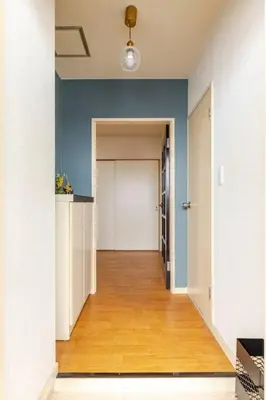 an empty hallway with blue walls and wooden floors at \u7acb\u77f35\u4e01\u76eem202 in Tokyo