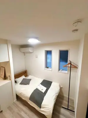 a bedroom with a bed in a room with windows at \u65b0\u4e951\u4e01\u76ee in Tokyo