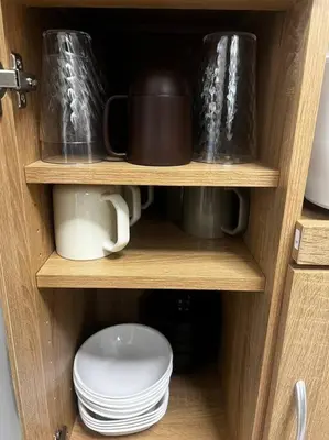 a wooden cabinet with cups and plates in it at \u65b0\u4e951\u4e01\u76ee in Tokyo
