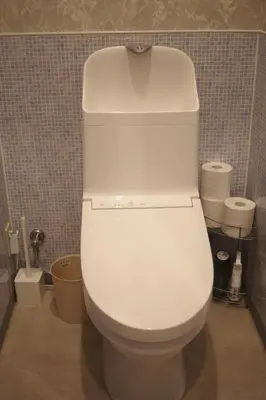 a white toilet in a bathroom with a tiled wall at MIYAVI hotel in Tokyo