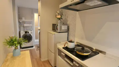 a kitchen with a stove and a microwave at MIZUKEN Home With Living Room And Sofa Bed in Tokyo