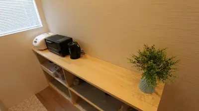 a wooden counter with a microwave and a plant on it at MIZUKEN Home With Living Room And Sofa Bed in Tokyo