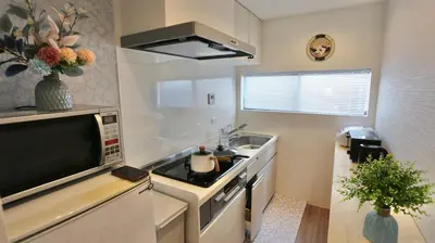 a small kitchen with a sink and a microwave at MIZUKEN Home With Living Room And Sofa Bed in Tokyo