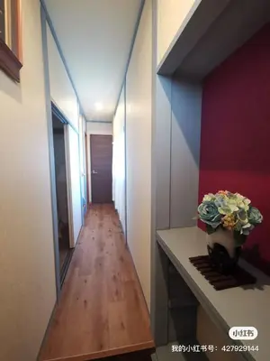 a hallway with a vase of flowers on a table and a mirror at \u5317\u5343\u4f4f\u306e\u4e00\u8ed2\u5bb6\u4ea4\u901a\u306e\u5229\u4fbf\u6027k1 in Tokyo
