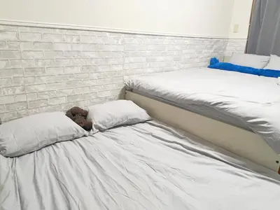 a dog sleeping on a bed with two pillows at \u6c60\u888b\u96fb\u8eca2\u5206\u6700\u59274\u4eba 302 in Tokyo