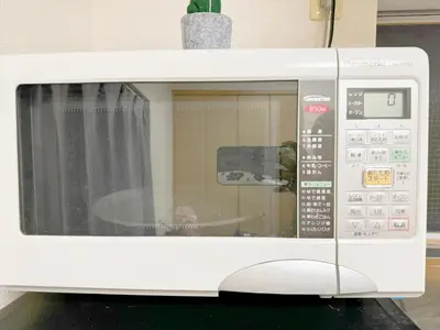 a white microwave oven sitting on top of a counter at \u6c60\u888b\u96fb\u8eca2\u5206\u6700\u59274\u4eba 302 in Tokyo